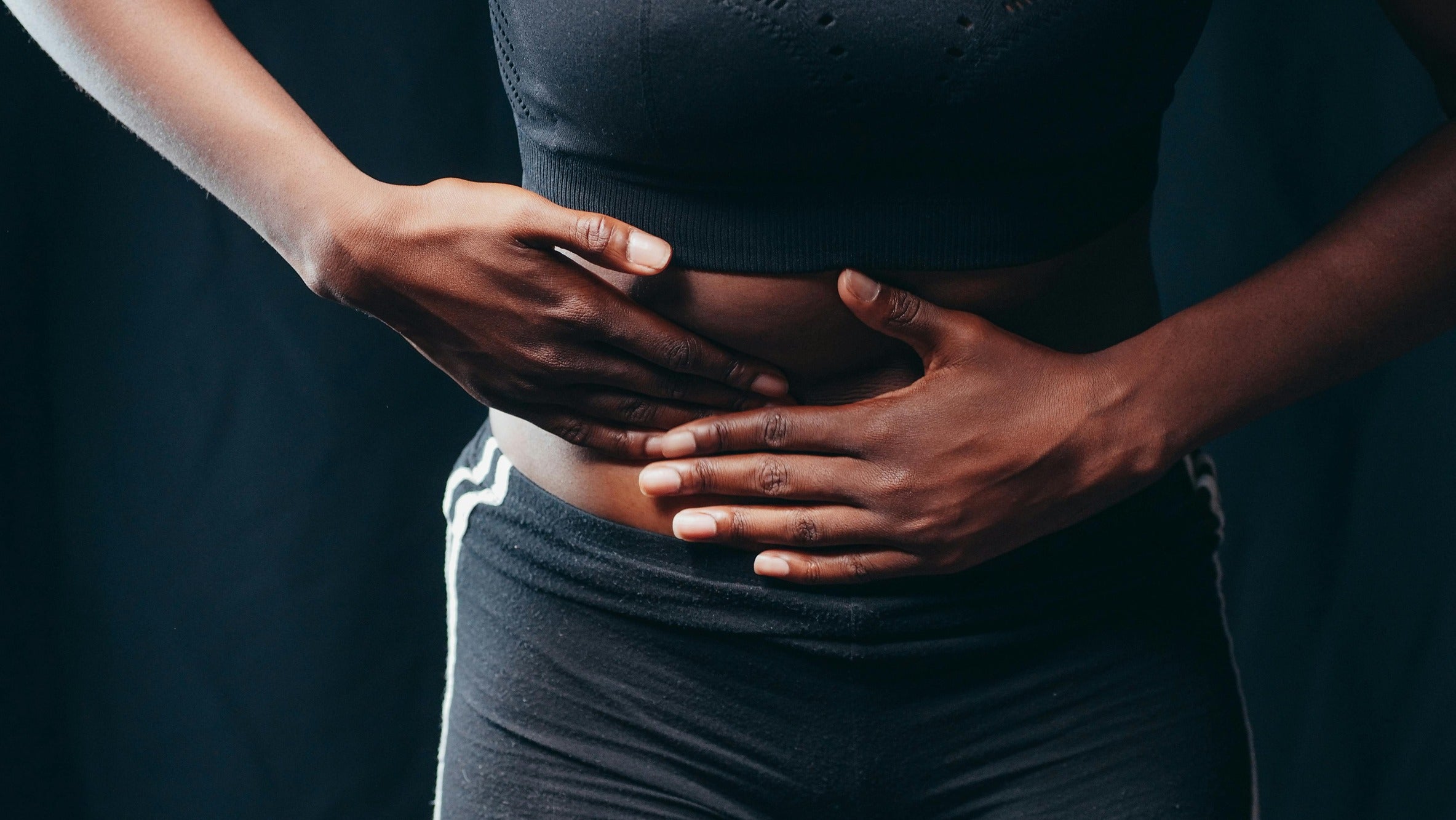 a person gently massaging their abdomen to relieve bloating and digestive discomfort.